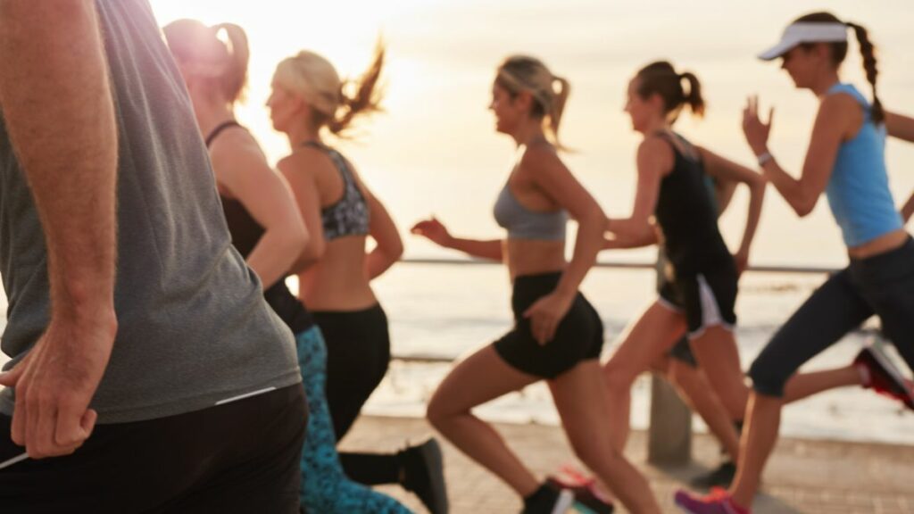 Groupe de coureuses en mouvement au bord de la mer lors d’un entraînement de course à pied